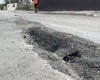Blestem, aruncat peste drumul care duce spre vilele bogaților din Iași! Abia peticit, a început din nou să se rupă în bucăți