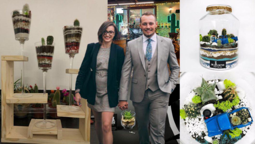 Bolurile de sticlă unde sunt cactuși, nisip, pietre și pământ, băiatul îmbrăcat în costum și fata cu ochelari (Flavian și Dumitrița)