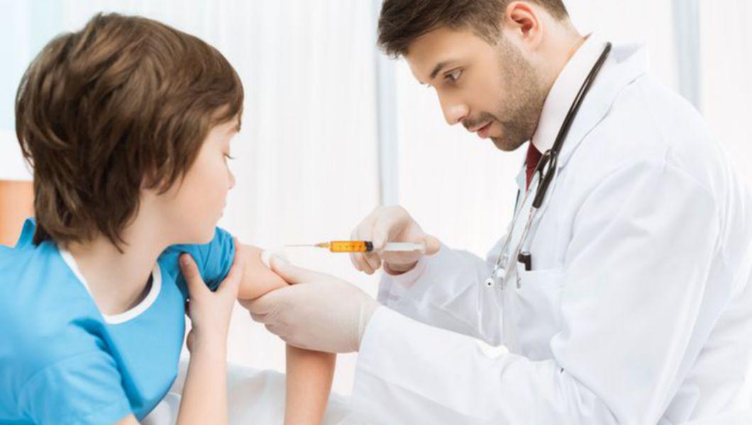 Un copil vaccinat de către un doctor