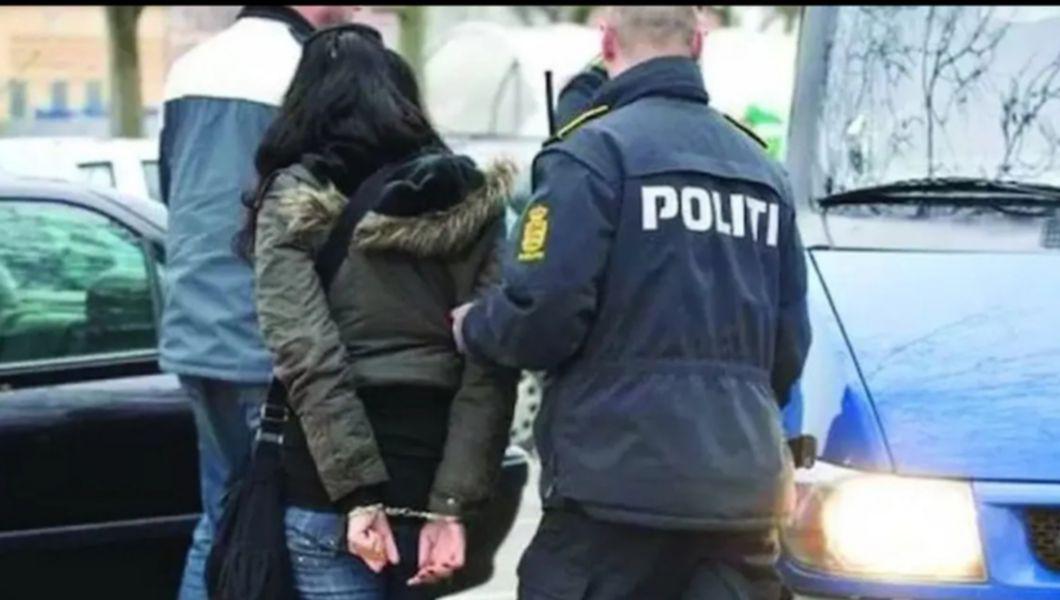 O femeie încătușată și un polițist