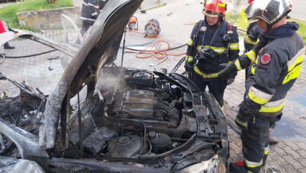 un pompier se uită la o mașină explodată la Arad