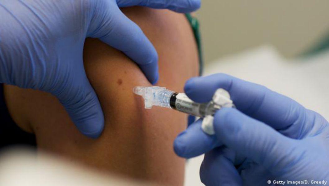 un cadru medical vaccinează o persoană