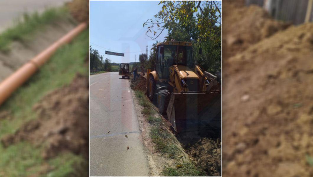 Muncitori care lucrează la montarea instalațiilor de racordare la rețeaua de alimentare cu apă în comuna Grajduri din județul Iași