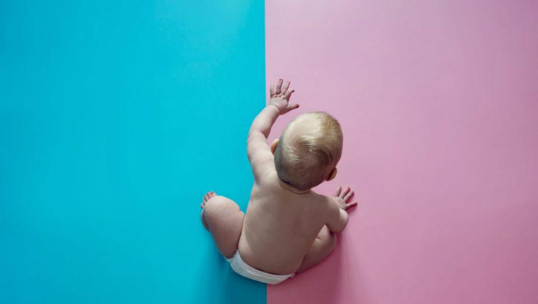 un bebeluș pe un fundal albastru cu roz