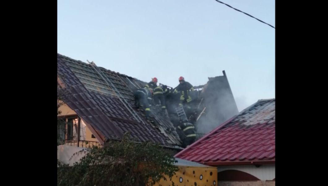 pompierii pe o casă cu acoperișul unei case