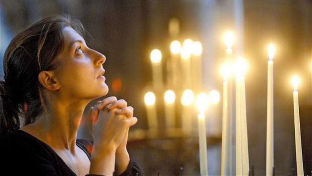 femeie care se roaga in biserica