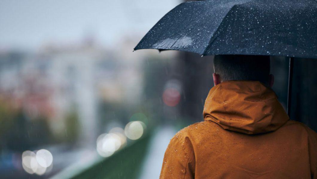 O persoană cu o umbrelă, pe o vreme ploioasă
