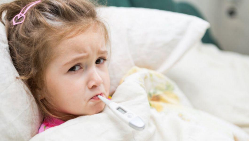 un copil răcit cu termometrul în gură