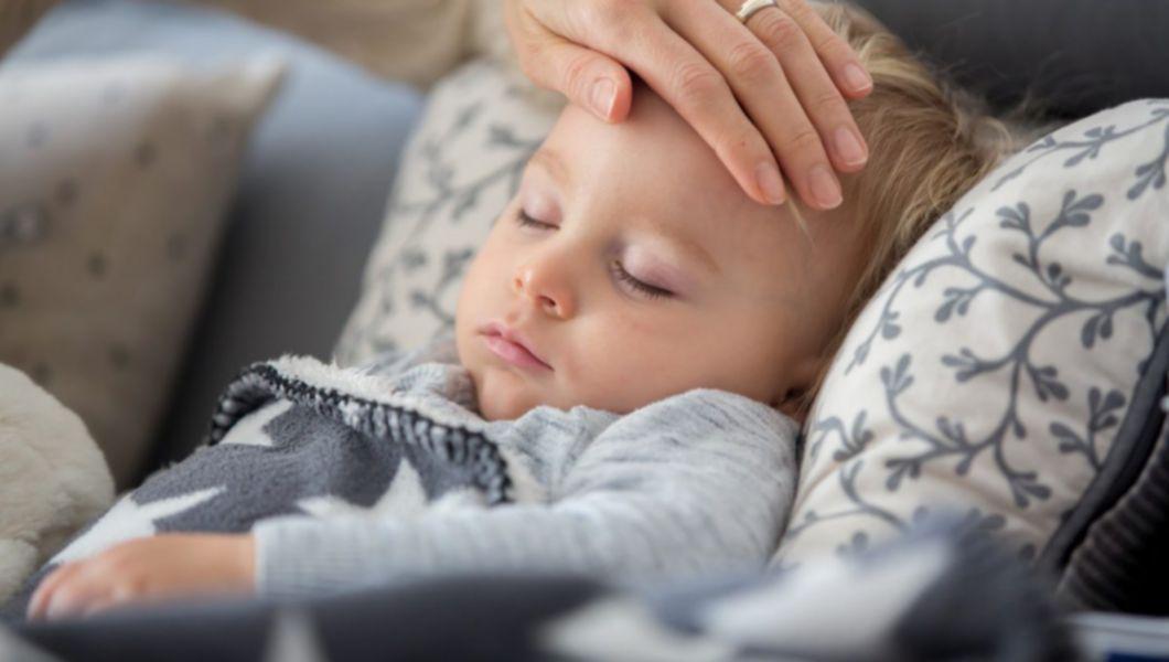 un copil care doarme și este controlat de febra