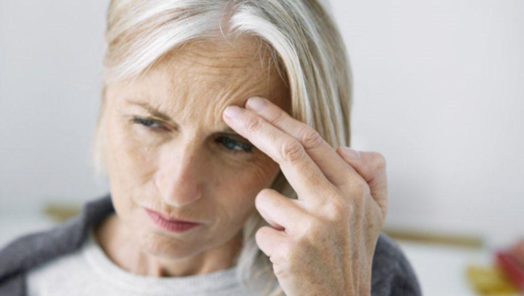 femeie care se tine de cap din cauza migrenei