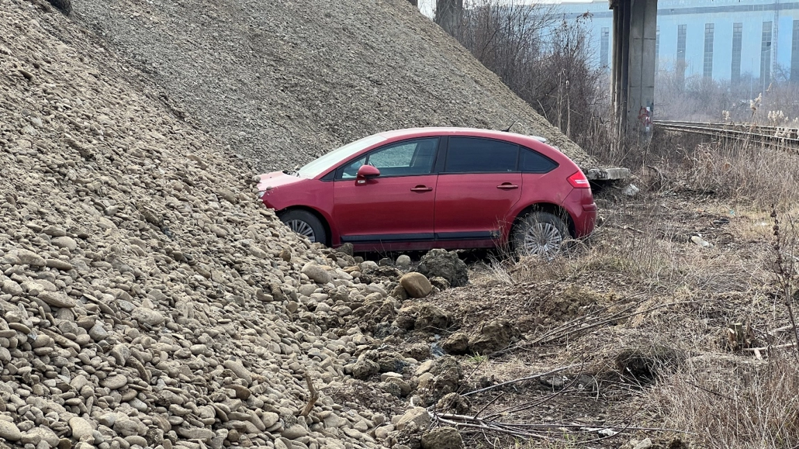 O mașină parcată lângă linia ferată din CUG a fost acoperită cu pietriș. Muncitorii au fost opriți de polițiști, înainte ca vehiculul să fie îngropat complet