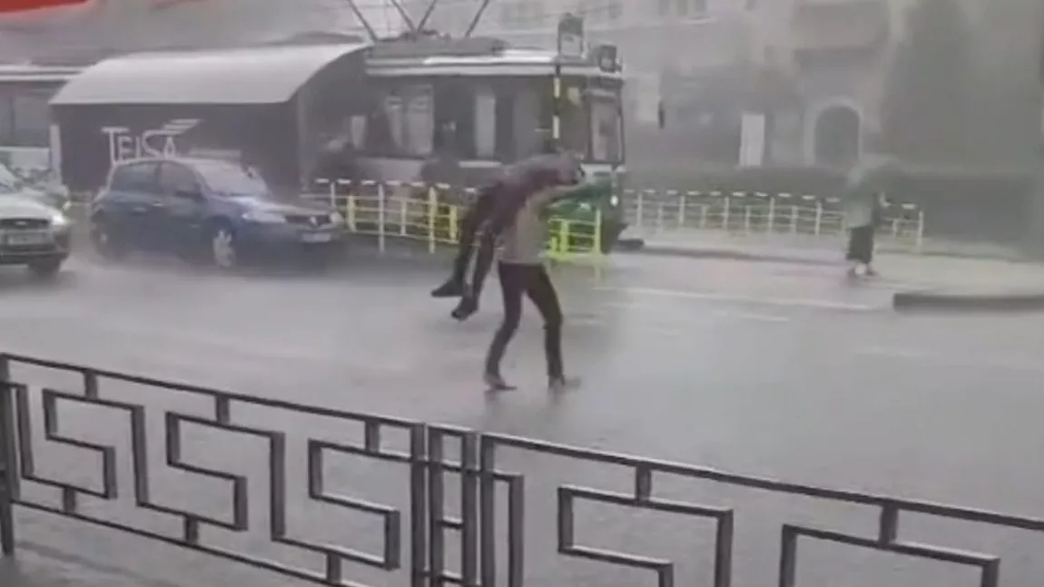 Așa ceva doar la Iași există! Să se apere de ploaie, un bărbat și-a luat pe sus prietenul, l-a pus deasupra capului și a fugit cu el spre stația de tramvai. Trecătorii au rămas șocați - FOTO/VIDEO
