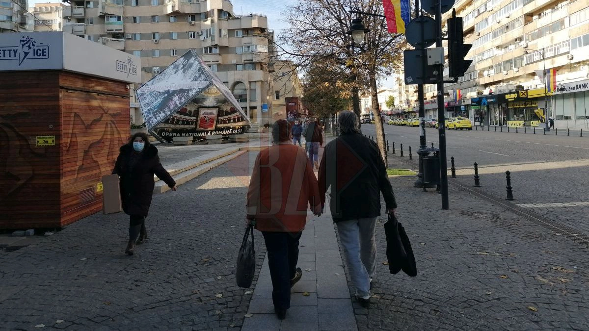 Ieșeni care se plimbă pe stradă cu masca pe față