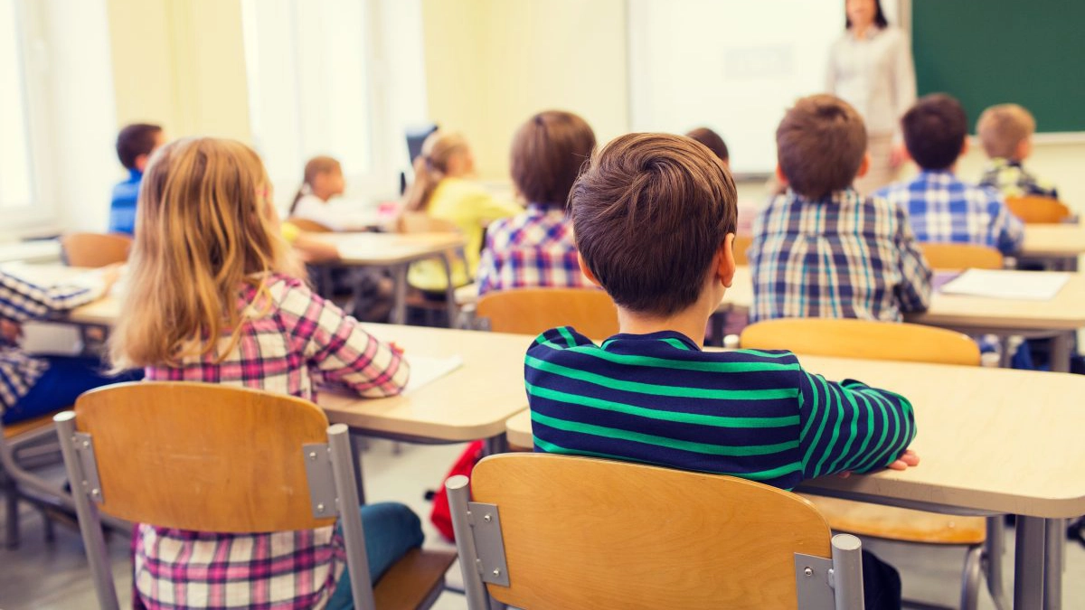 group of school kids and teacher in classroom