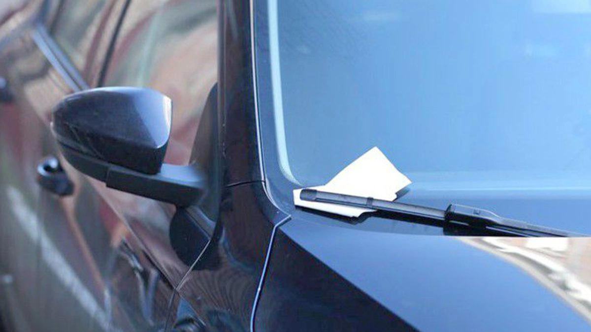 Mesaj-lăsat-pe-o-foaie-de-hârtie-pe-parbrizul-unui-autoturism
