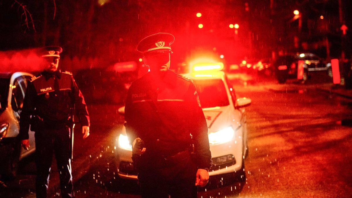 Doi-polițiști-în-uniformă-cu-autospeciala-de-poliție-cu-girofarul-pornit-pe-timp-de-noapte