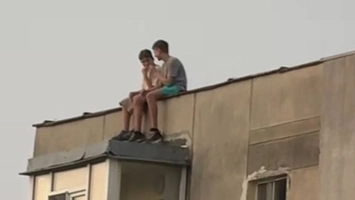 Inconștiență dusă la extrem. Doi copii au fost fotografiați pe acoperișul unui bloc de 10 etaje din Alexandru cel Bun. Au picioarele pe exterior