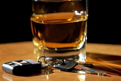 un pahar cu alcool si cheile unei masini pe o masa