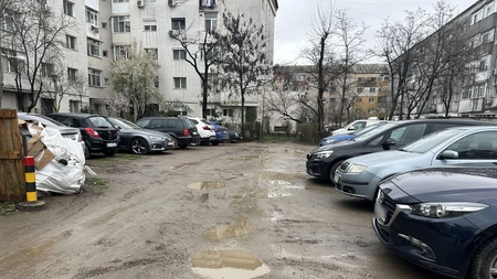 O parcare rezidențială din cartierul Galata din Iași arată ca după război: spațiile verzi sunt distruse de mașini, iar strada este plină de gropi