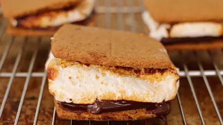 Rețetă virală de S’mores. Sandviș cu biscuiți graham, ciocolată și bezele la foc