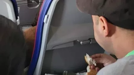 Doi români, filmați mâncând cârnați, brânză și roșii în avion. Imaginile fac deliciul internauților
