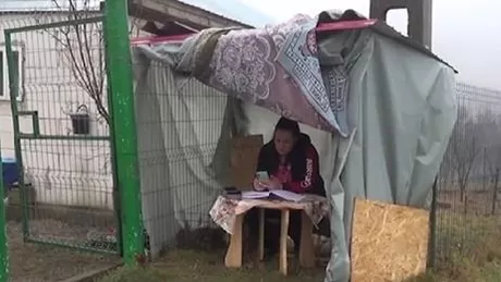 Eleva de liceu care învaţă în baraca din faţa casei indiferent de vreme