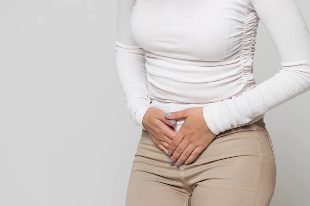 femeie cu dureri de burta ce sta la perete in primele saptamani din timpul sarcinii