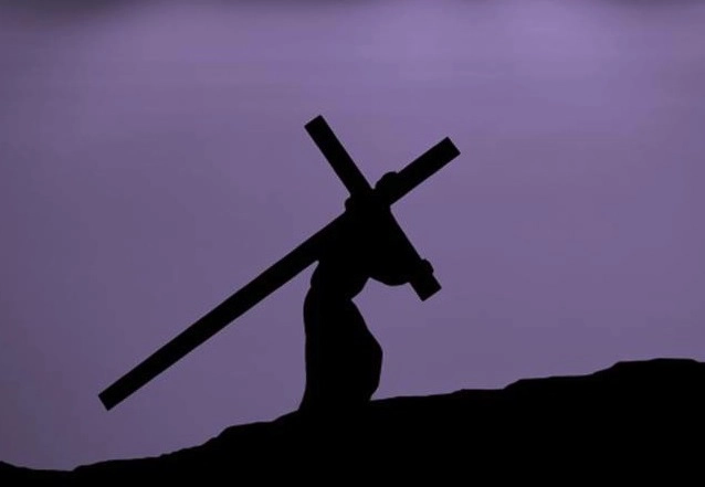 un om care duce în spate o cruce