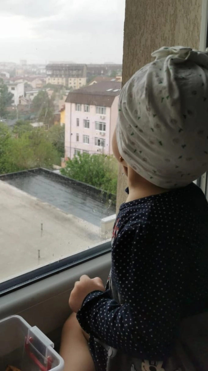  un copil care privește pe geam