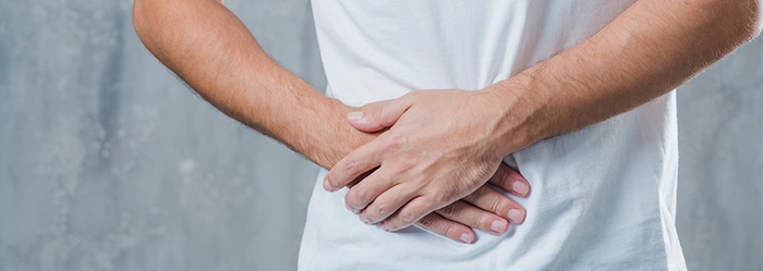 barbat care se tine de partea dreapta a abdomenului din cauza durerii