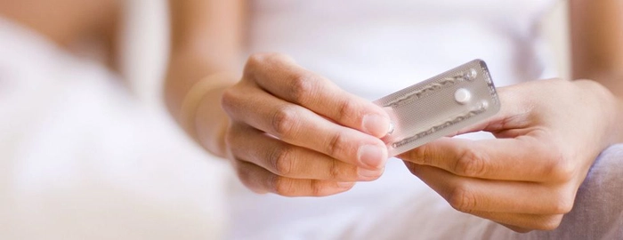 femeie care tine pastile pentru intreruperea sarcinii in mana