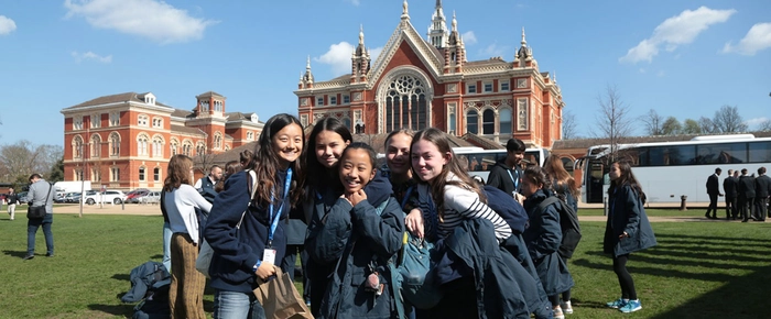 grup de elevi cu ghiozdanul in spate langa Tower Bridge