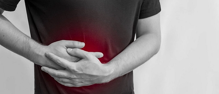 un bărbat care tine mainile pe abdomen