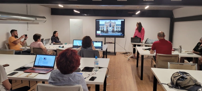  o sala de clasa si profesori uitandu-se la un ecran