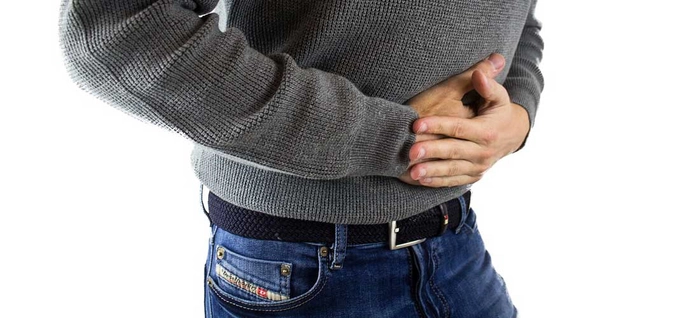 persoana care se tine de stomac din cauza sistemului digestiv
