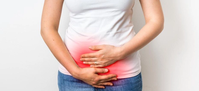 grafica femeie care se tine de abdomen din cauza infectiei urinare