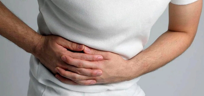 persoana care se tine de partea dreapta a abdomenului din cauza unei crize de fiere