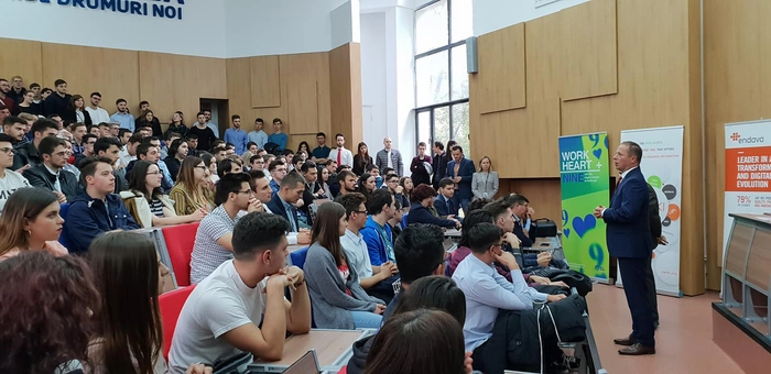 un amfiteatru plin de studenti care asculta un seminar