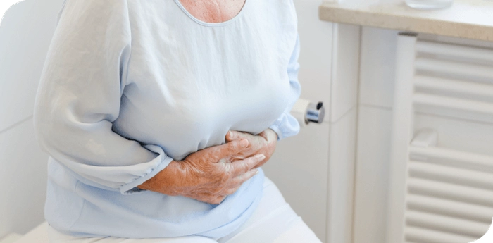 persoana care se tine de stomac din cauza sistemului digestiv