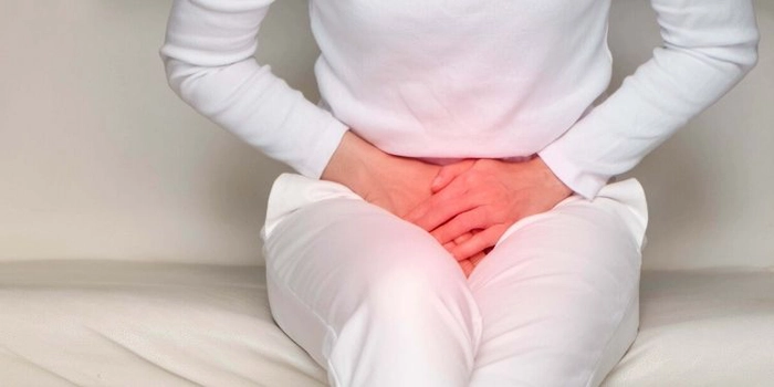 grafica femeie care se tine de burta din cauza durerii provocate de infectia urinara