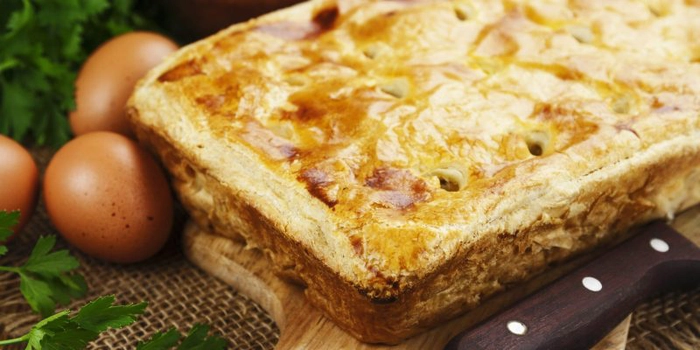 o prajitura din aluat foietaj congelat langa doua oua pe un fund de lemn