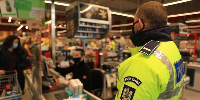un angajat al Politiei Romane care se afla la casa de marcat a unui supermarket