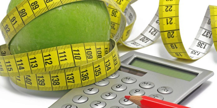 calculator langa un creion si un mar infasurat cu un metru