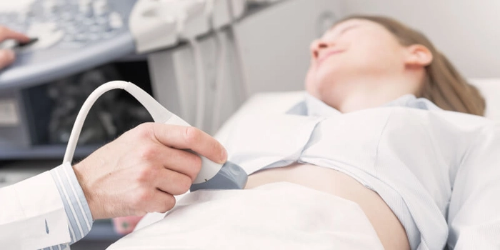 persoana care efectueaza o ultrasonografie unei femei
