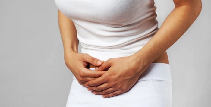 femeie care se tine de josul abdomenului din cauza durerii