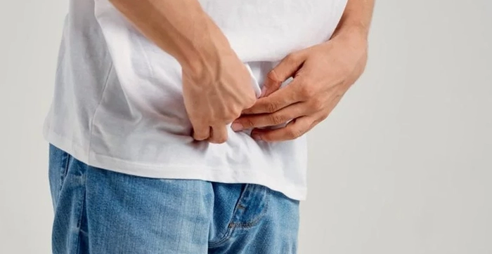 persoana care apasa pe zona inghinala din cauza unui disconfort