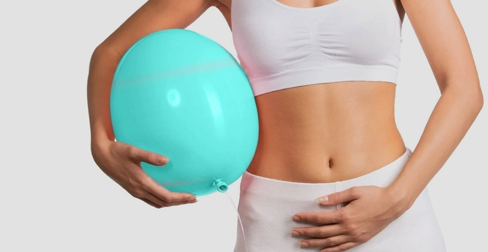 femeie care se tine de burta si are un balon in mana