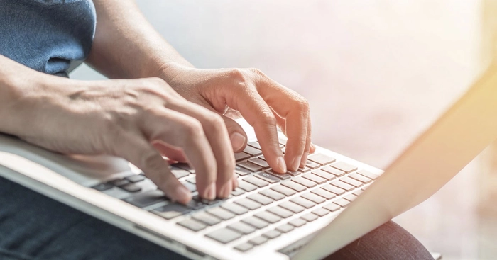  o persoana care scrie pe laptop