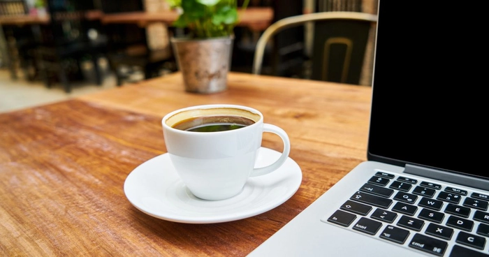 ceasca de cafea langa un laptop