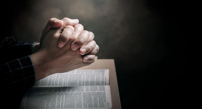 persoana care roaga cu biblia deschisa